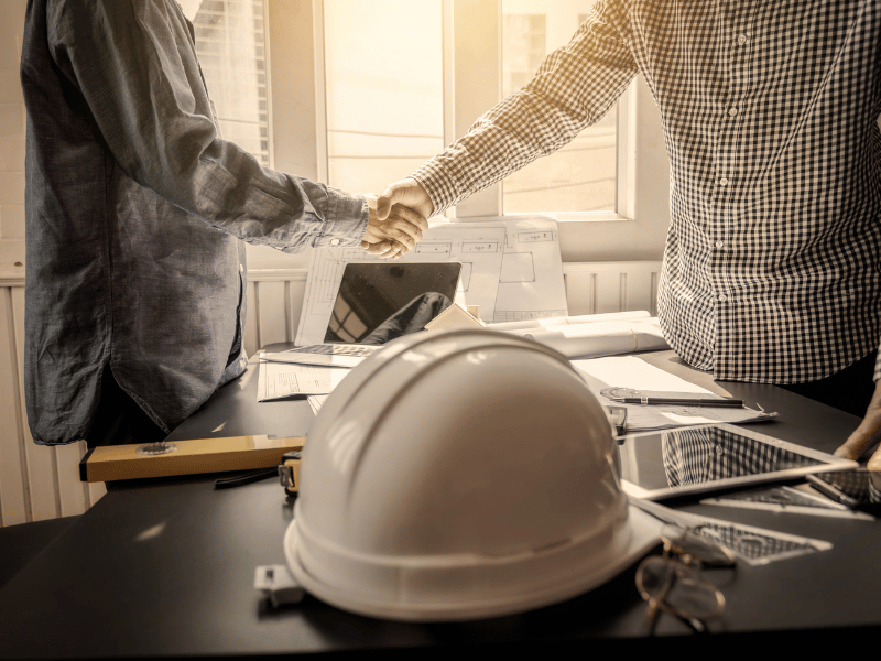 construction business owner shaking hands, taking on a new bookkeeper